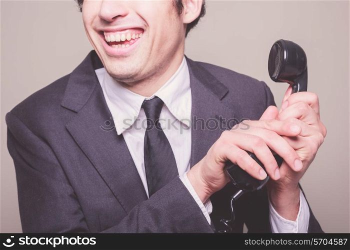 Happy young businessman is on the phone