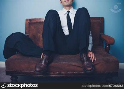 Happy young businessman sitting on a sofa
