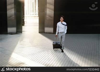 Happy Young Businessman Walking with Suitcase in the City. Modern Male in Business Trip. Front View. Full Length