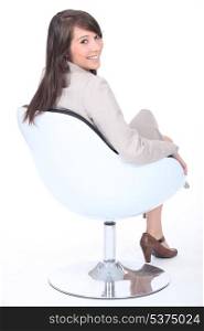 Happy young businesswoman in a swivel chair