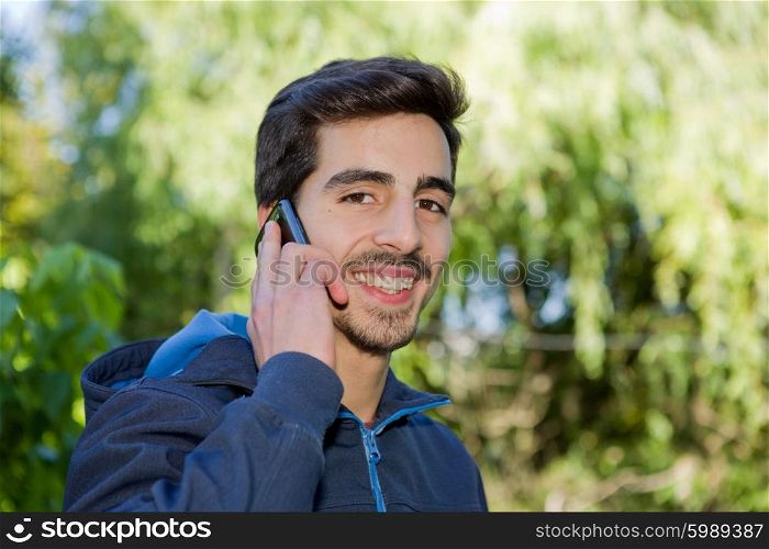 happy young casual man on the phone outdoor