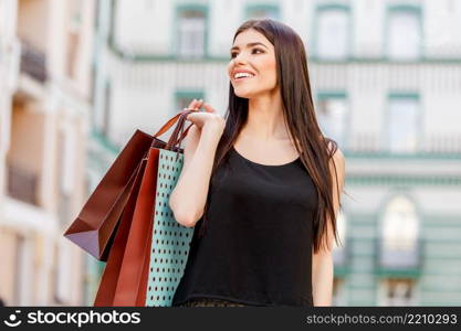 happy young caucasian woman with shopping bags outdoor. happy young woman with shopping bags