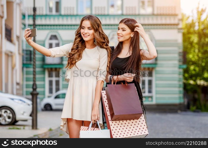 happy young caucasian women with shopping bags outdoor. happy young women with shopping bags