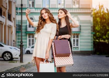 happy young caucasian women with shopping bags outdoor. happy young women with shopping bags