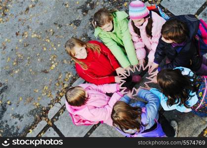 happy young child group outdoor standing together in circle formation and representing teamwork and friendship concept