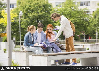 Happy young college friends studying together at campus