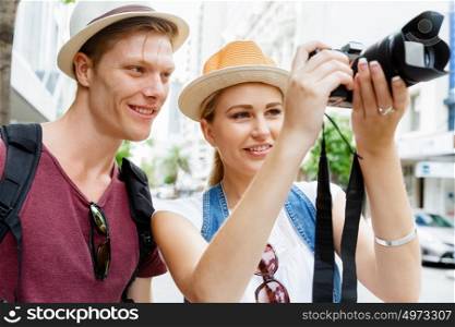 Happy young couple as tourists with a camera. That will be a great picture
