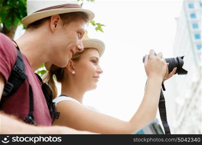 Happy young couple as tourists with a camera. That will be a great picture