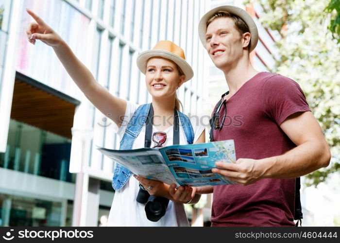 Happy young couple as tourists with a map. Look what we have there