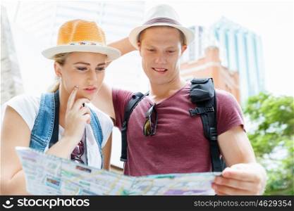 Happy young couple as tourists with a map. New places to explore