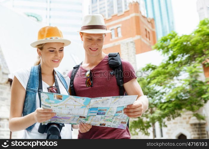 Happy young couple as tourists with a map. New places to explore