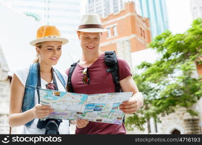 Happy young couple as tourists with a map. New places to explore