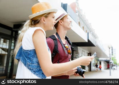 Happy young couple as tourists with a map. New places to explore