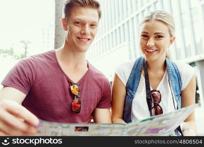 Happy young couple as tourists with a map. New places to explore