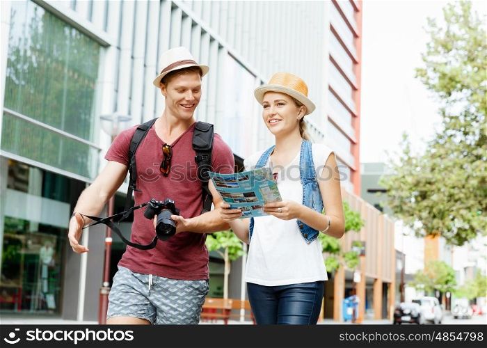Happy young couple as tourists with a map. New places to explore