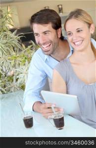 Happy young couple at home using electronic tablet