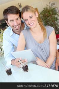 Happy young couple at home using electronic tablet