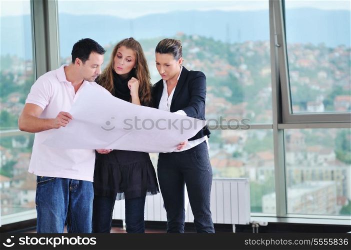 happy young couple buying new home with real estate agent and looking big comfort bright apartment plans and taking key