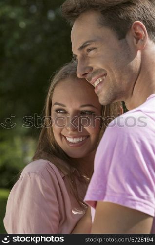 Happy young couple embracing in park