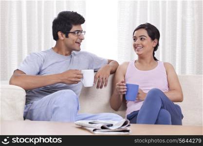 Happy young couple enjoying coffee at home