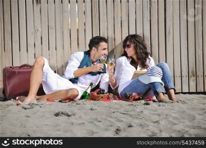 happy young couple enjoying picnic on the beach and have good time on summer vacations