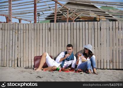 happy young couple enjoying picnic on the beach and have good time on summer vacations