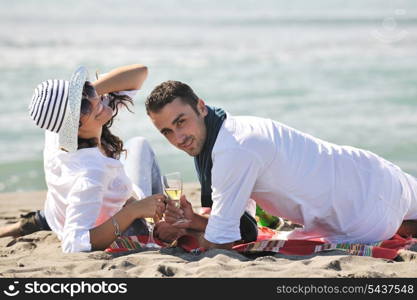 happy young couple enjoying picnic on the beach and have good time on summer vacations