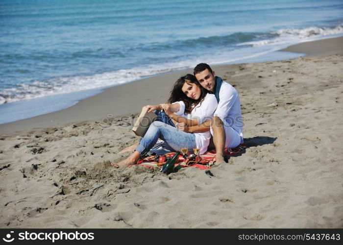 happy young couple enjoying picnic on the beach and have good time on summer vacations