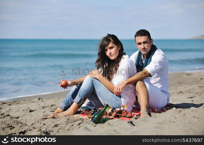 happy young couple enjoying picnic on the beach and have good time on summer vacations