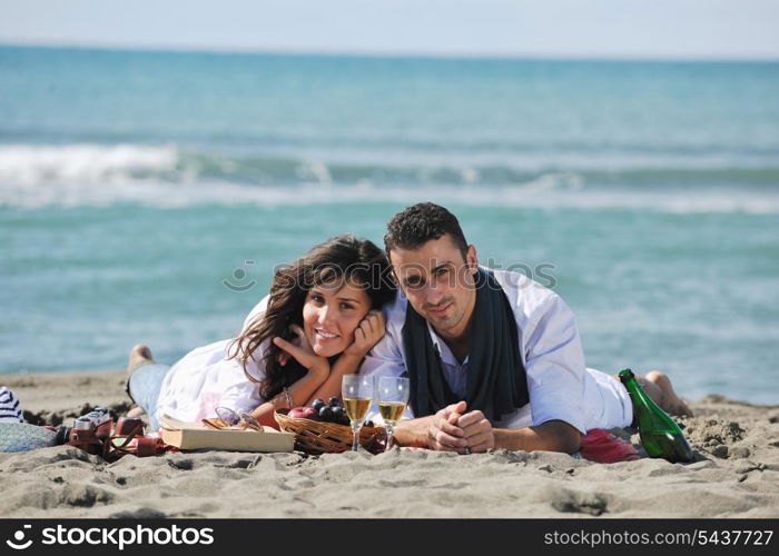 happy young couple enjoying picnic on the beach and have good time on summer vacations