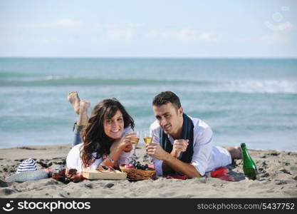 happy young couple enjoying picnic on the beach and have good time on summer vacations