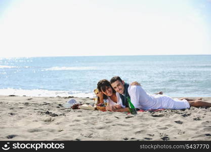 happy young couple enjoying picnic on the beach and have good time on summer vacations