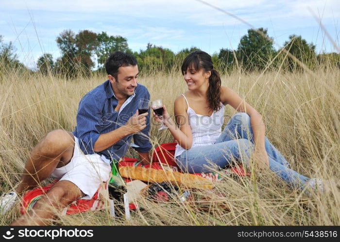 happy young couple enjoying picnic on the countryside in the field and have good time