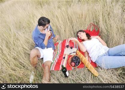 happy young couple enjoying picnic on the countryside in the field and have good time