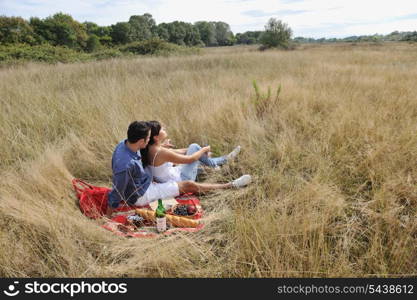 happy young couple enjoying picnic on the countryside in the field and have good time