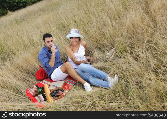 happy young couple enjoying picnic on the countryside in the field and have good time