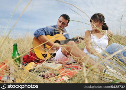 happy young couple enjoying picnic on the countryside in the field and have good time