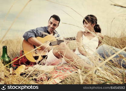 happy young couple enjoying picnic on the countryside in the field and have good time