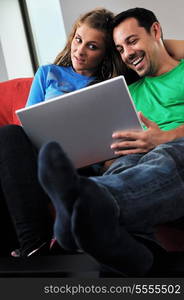 happy young couple have fun and relax at comfort bright apartment and work on laptop computerhappy young couple have fun and relax at comfort bright appartment and work on laptop computer