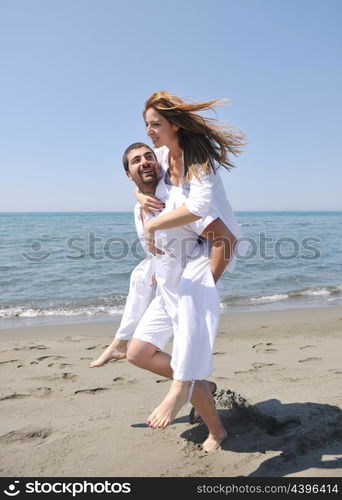 happy young couple have fun and romantic moments on beach at summer season and representing happynes and travel concept