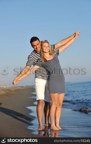 happy young couple have romantic time on beach at sunset