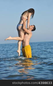 happy young couple have romantic time on beach at sunset