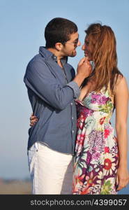 happy young couple have romantic time on beach at sunset