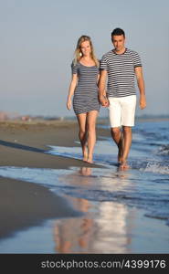 happy young couple have romantic time on beach at sunset