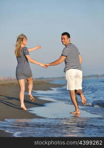 happy young couple have romantic time on beach at sunset