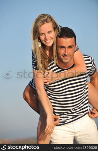 happy young couple have romantic time on beach at sunset