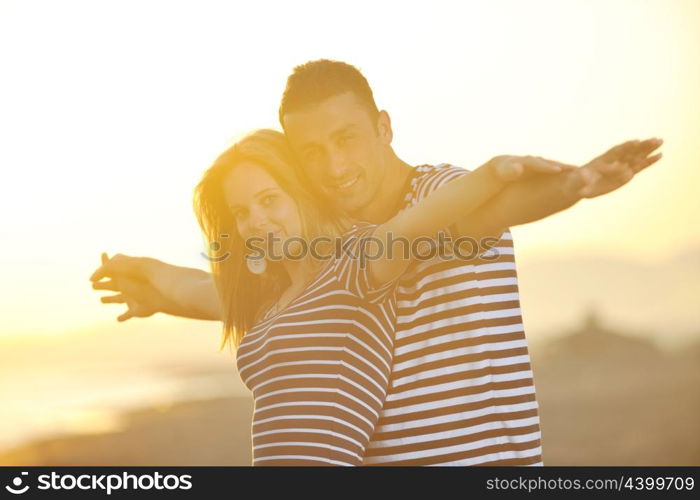 happy young couple have romantic time on beach at sunset