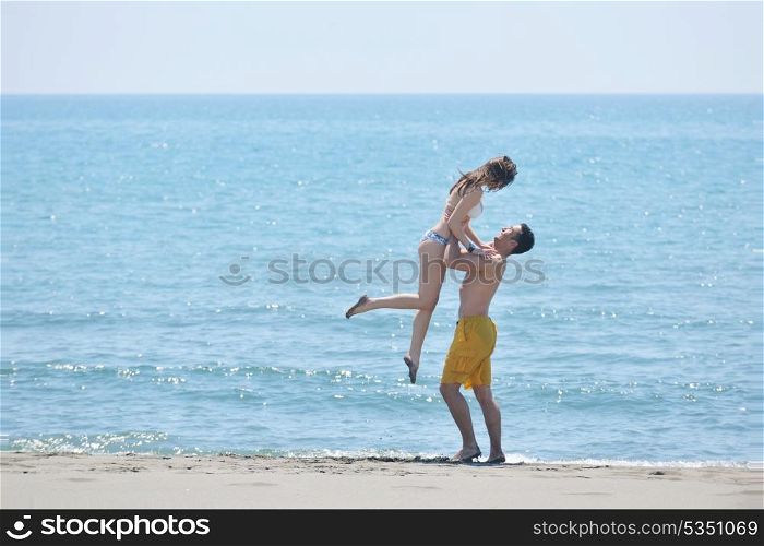 happy young couple have romantic time on beach at sunset