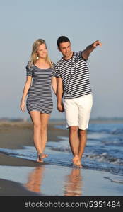 happy young couple have romantic time on beach at sunset