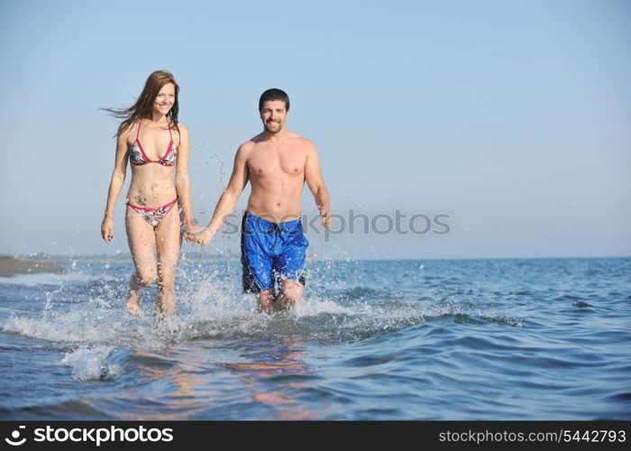 happy young couple have romantic time on beach at sunset